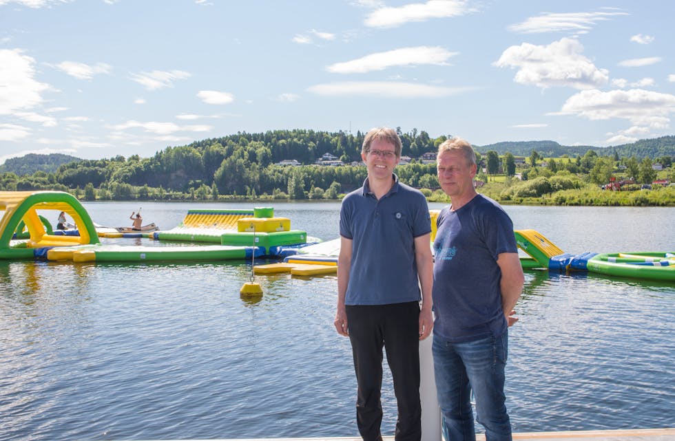 Hans Jørgensen og Vidar Høglid fra Bryggeparken drift håper på mange badegjester i sommer. Fredag fikk de hjelp fra et Nome fotball-lag som var med på dugnaden med å få elementene på vannet. 