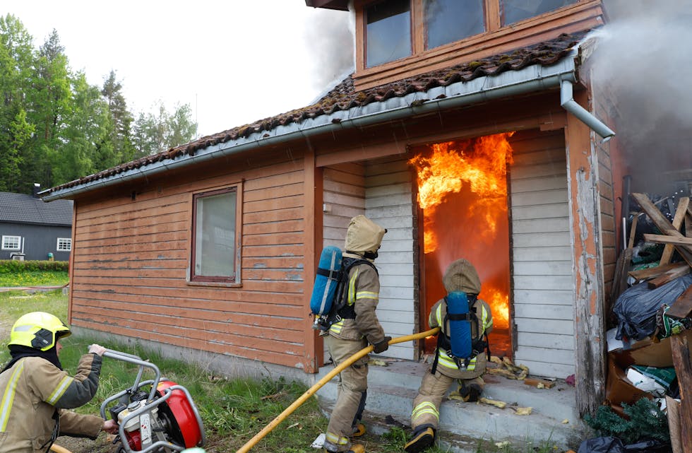 TEMMER ILDEN: Røykdykkerne tester en ny slukningsmetode mot ildveggen før de kan gå inn i huset.