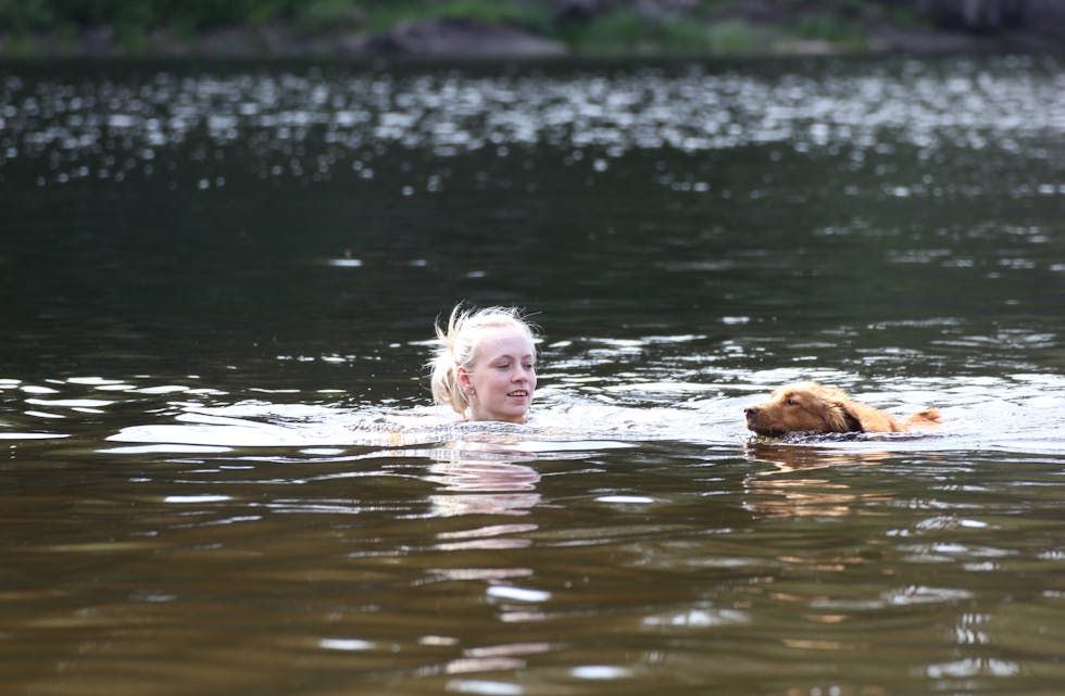 DEILIG VANN: Tonje Funnemark Dalen og hunden Bella kunne bekrefte at vannet i Norheimstjønna har blitt varmere den siste tida.

