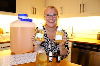 SÅPEKOKER:i – Jeg lager såpe av fett, lut og kaldt vann. Her er flytende såpe, en 10 liters dunk blir til 34 slike flasker, sier Anne-Jorunn Strand. 