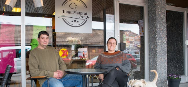 Tom Marin og Heidi Kristina Dale, for anledningen med maskoten, Wheaten terrieren Cian, viser fram den nye butikken «Toms Matprat» i Brugata i Lunde. 